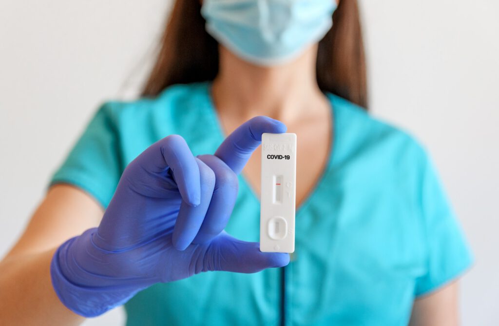 Selective focus closeup image of doctor holding covid antigen rapid test.
