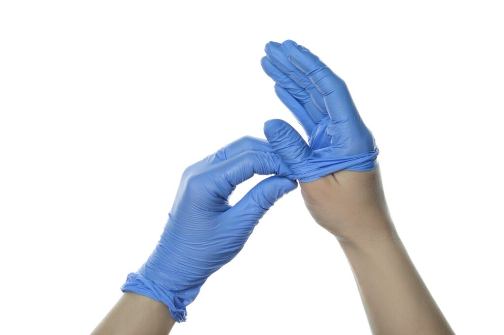 Hands take off medical gloves, isolated on white